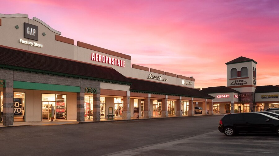 St. Augustine Premium Outlets which includes signage, shopping and a sunset
