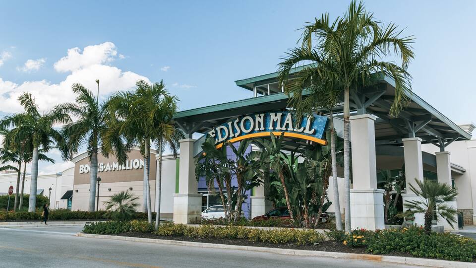 A shopping mall entrance with a sign reading "EDISON MALL" and palm trees.