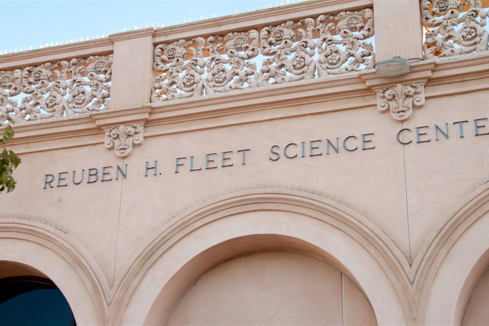 Fachada del Centro de Ciencias Reuben H. Fleet, con elaborados grabados y entradas arqueadas.