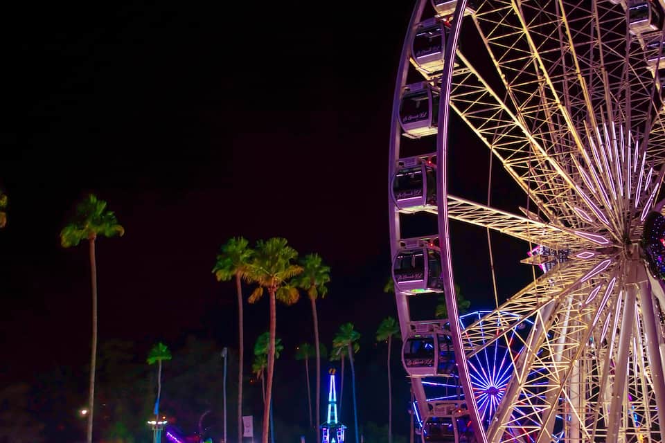 A large Ferris wheel with illuminated cabins at night.