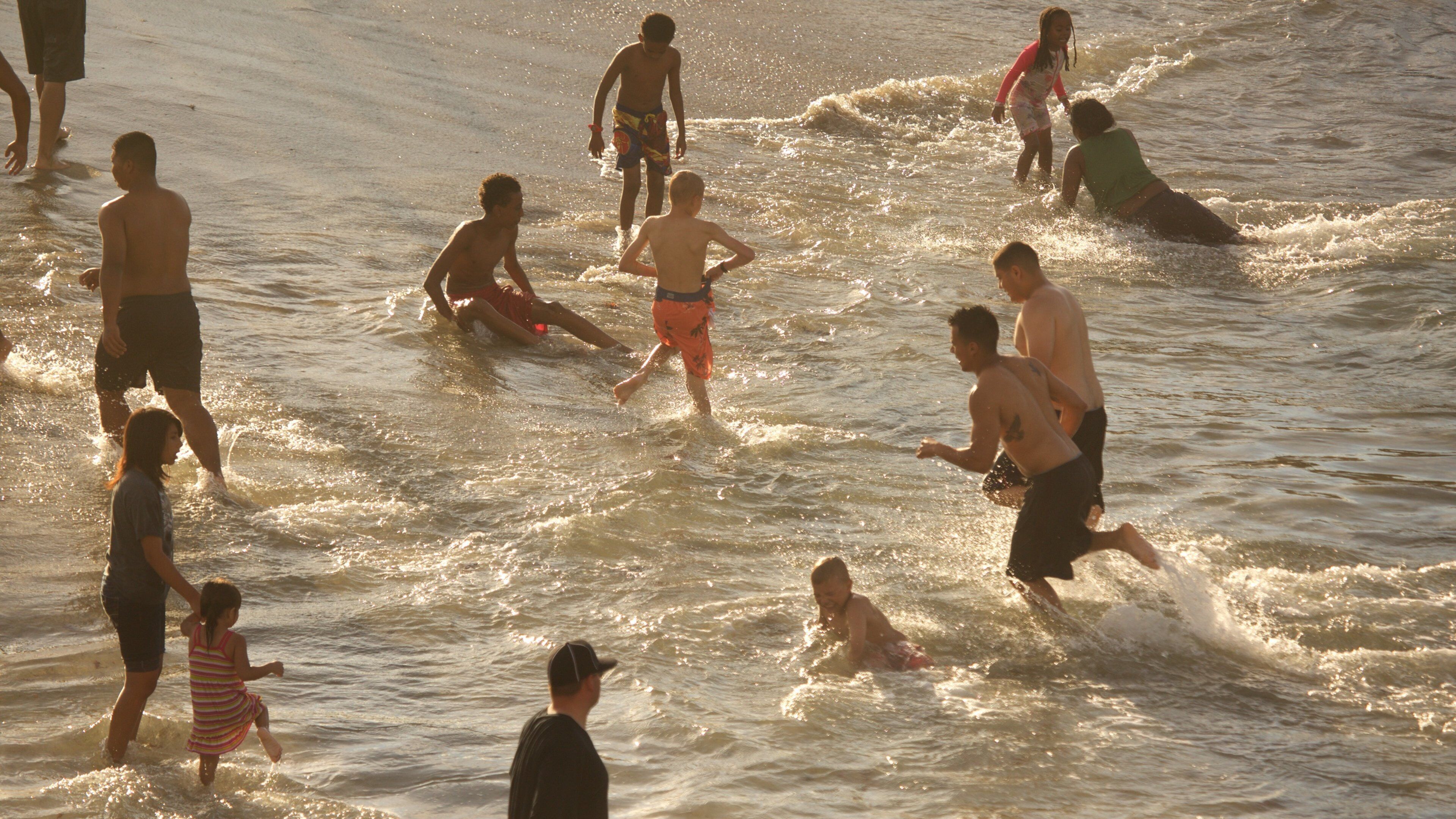 La Jolla Cove showing a sandy beach and a sunset as well as a large group of people