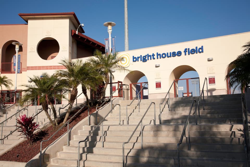 A building with a sign reading "Bright House Field" and a set of stairs leading up to it.