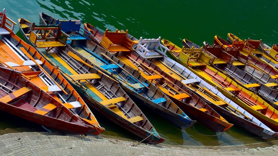 A row of colorful rowboats docked at a pier.