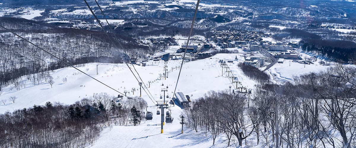 A snow-covered mountain with a ski lift in the foreground.
