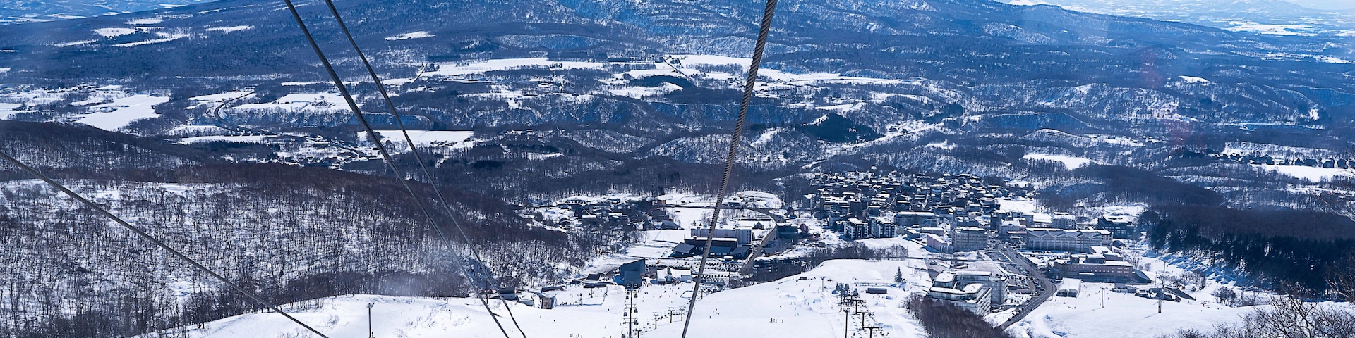 A snow-covered mountain with a ski lift in the foreground.