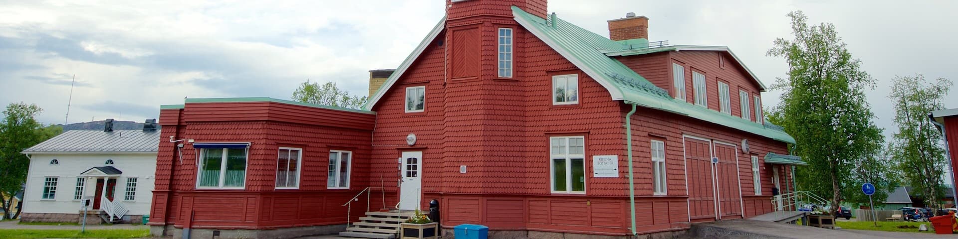 A red lighthouse with a white balcony and a green roof.