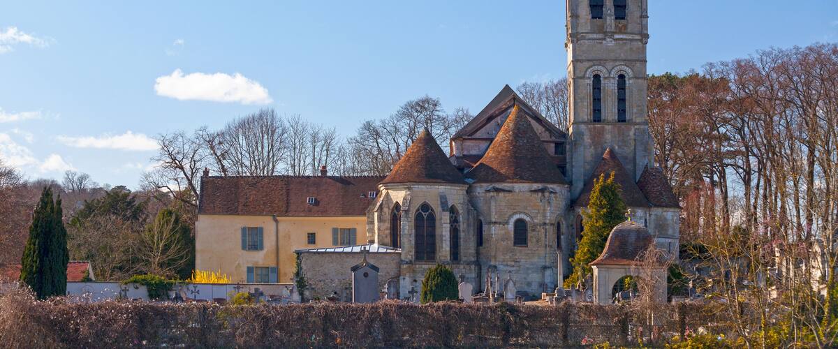 A historic church with a tall bell tower and a smaller adjacent building.