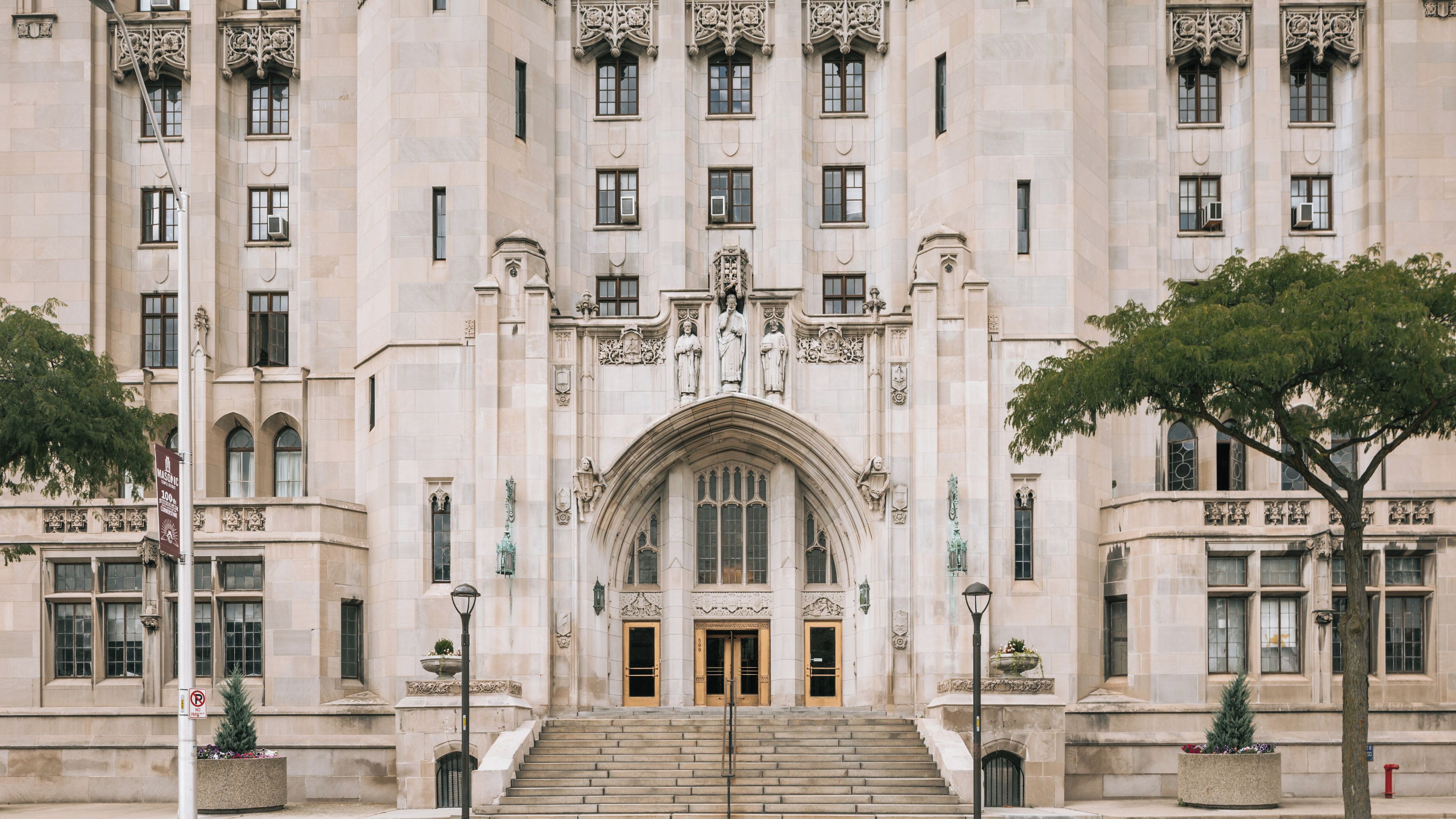 A large, ornate building with a grand entrance, featuring a series of statues and intricate architectural details.