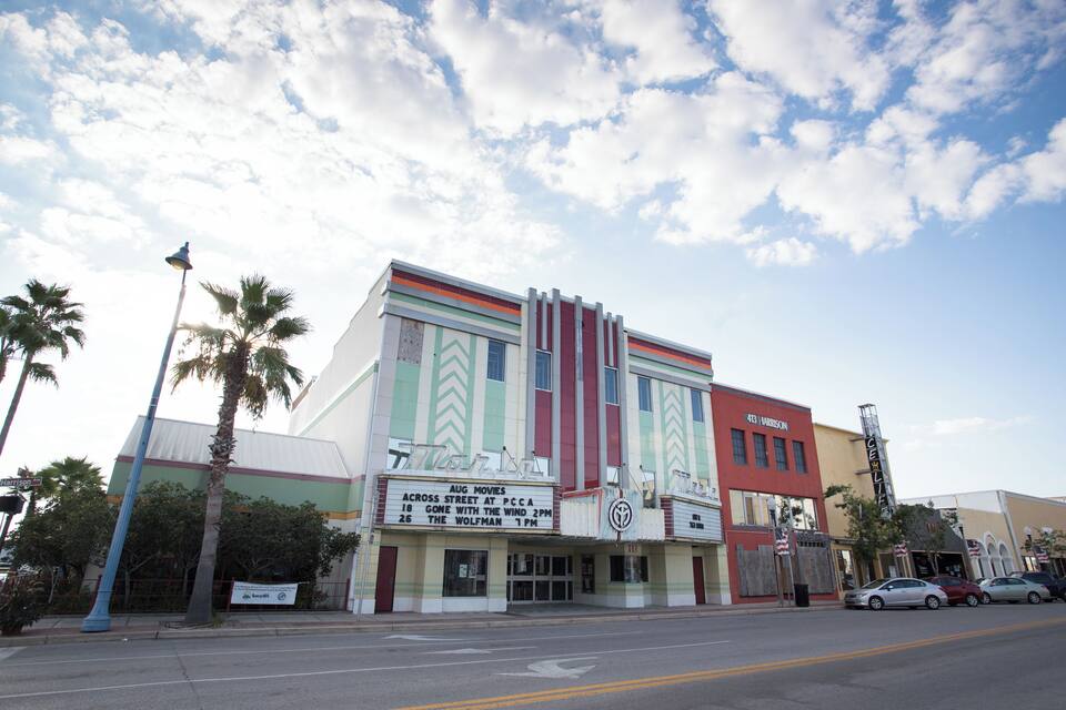 A vintage movie theater with a marquee advertising films like 'Gone with the Wind' and 'The Wolfman'.