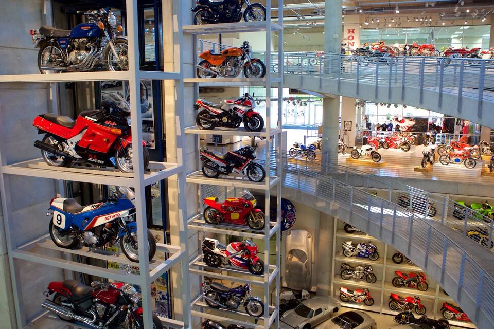 Una sala de exposición de motocicletas con varios niveles y diferentes modelos exhibidos en estanterías.