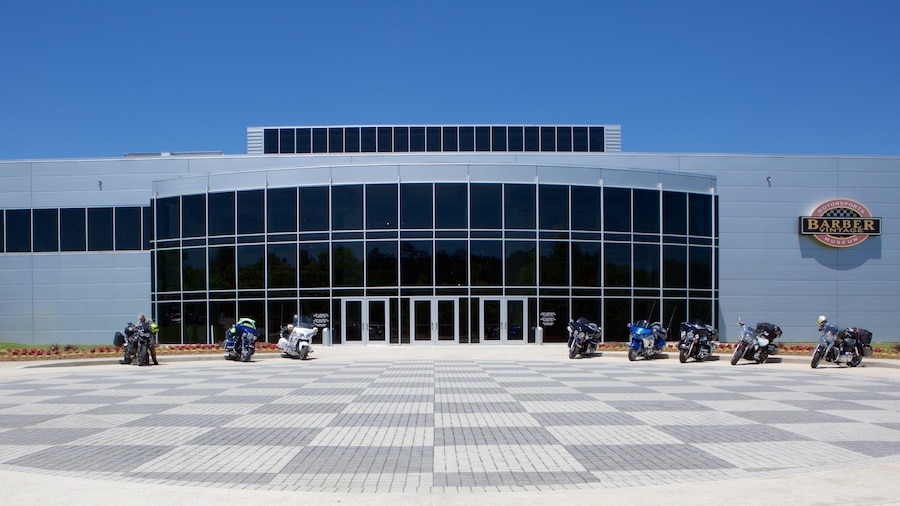 Un edificio moderno con una amplia fachada de vidrio y el logotipo de Harley-Davidson a la derecha.