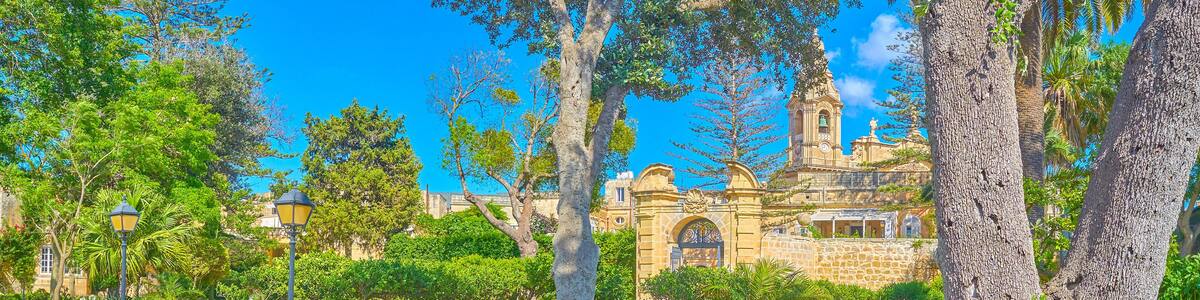 NAXXAR, MALTA - JUNE 14, 2018: The picturesque Italian gardens of Palazzo Parisio, also famous as Scicluna Palace, with shady green trees, flower beds and fountains, on June 14 in Naxxar.