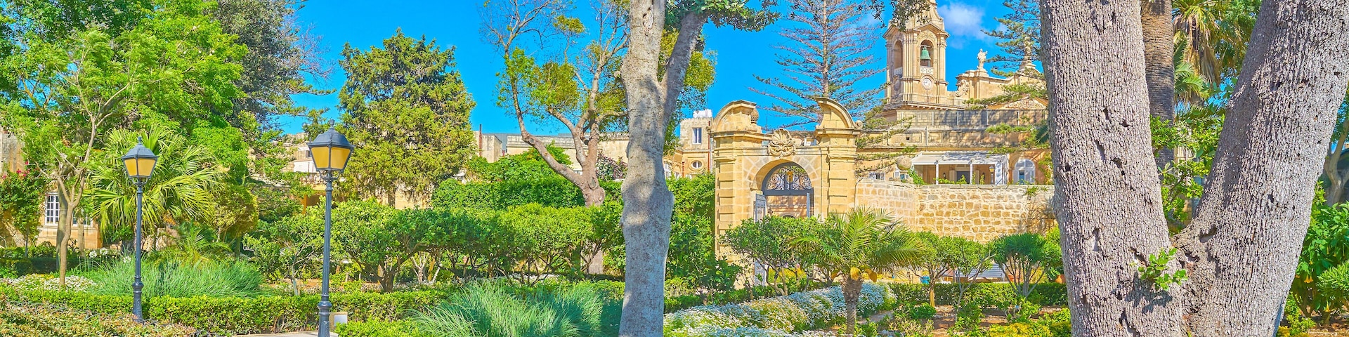 NAXXAR, MALTA - JUNE 14, 2018: The picturesque Italian gardens of Palazzo Parisio, also famous as Scicluna Palace, with shady green trees, flower beds and fountains, on June 14 in Naxxar.