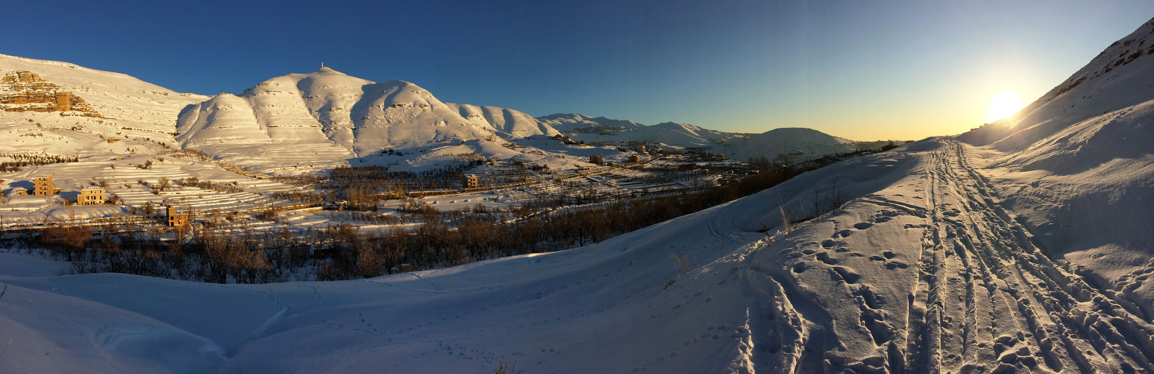panorama under the snow, mount Lebanon in winter, part of the landscape around the village of FARAYA, Keserwen, Lebanon with the  bright new  monumental statue of saint Charbel on the top of the hill