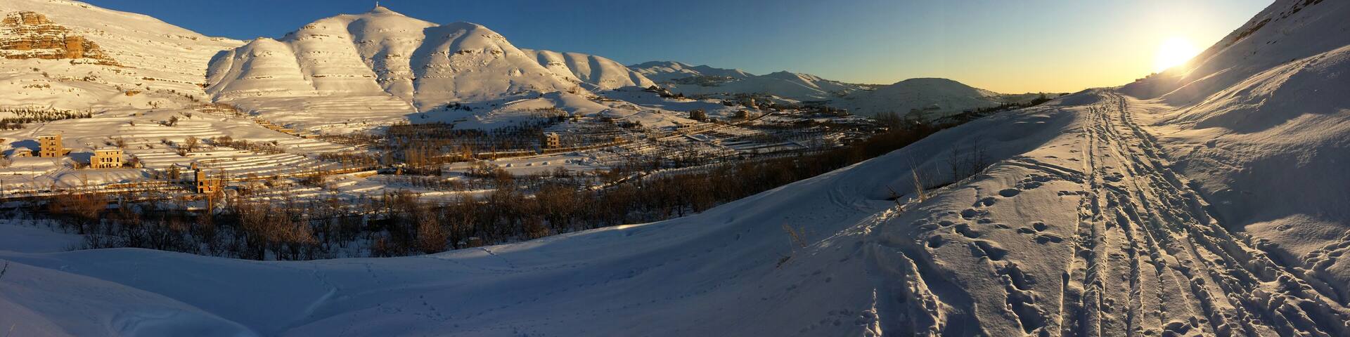 panorama under the snow, mount Lebanon in winter, part of the landscape around the village of FARAYA, Keserwen, Lebanon with the bright new monumental statue of saint Charbel on the top of the hill