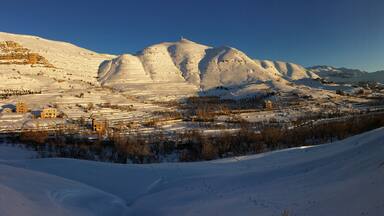 panorama under the snow, mount Lebanon in winter, part of the landscape around the village of FARAYA, Keserwen, Lebanon with the bright new monumental statue of saint Charbel on the top of the hill