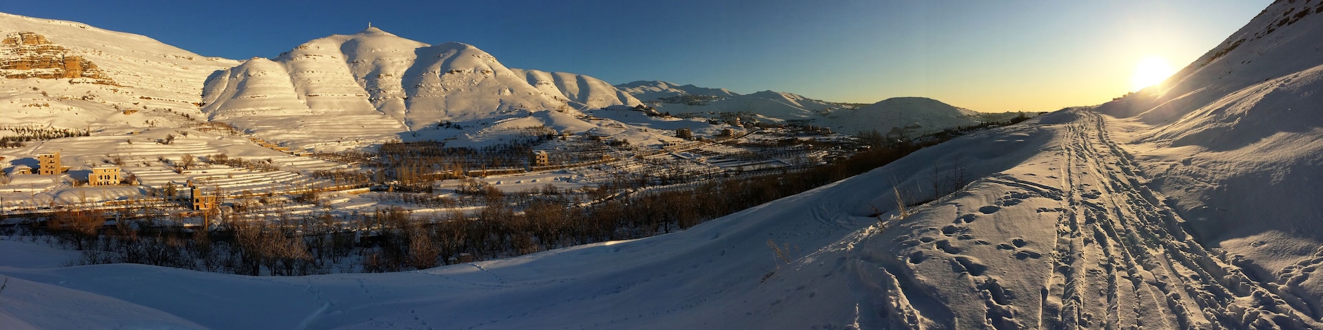 panorama under the snow, mount Lebanon in winter, part of the landscape around the village of FARAYA, Keserwen, Lebanon with the bright new monumental statue of saint Charbel on the top of the hill