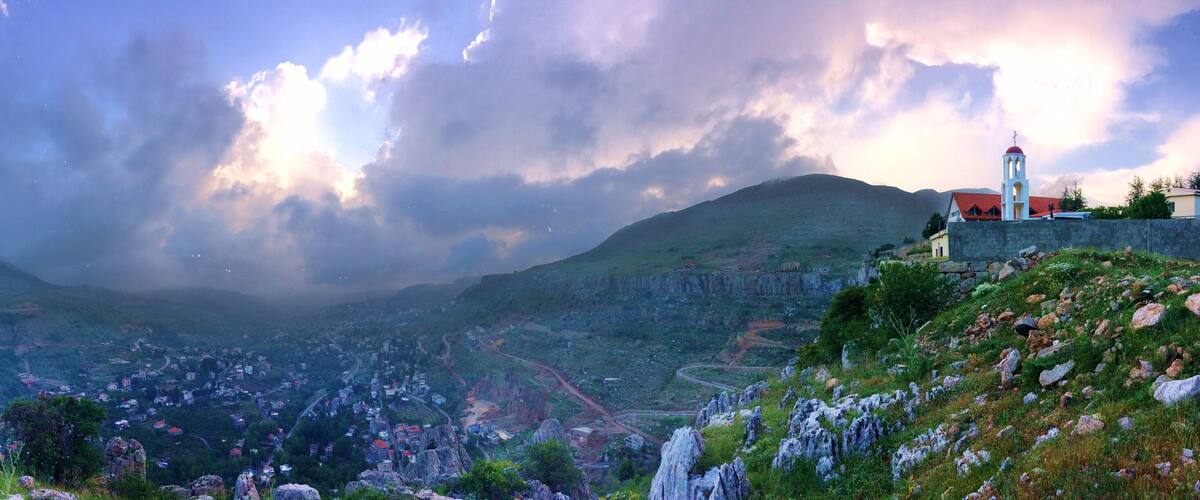 A mountainous landscape with a village, a church, and a communication tower.