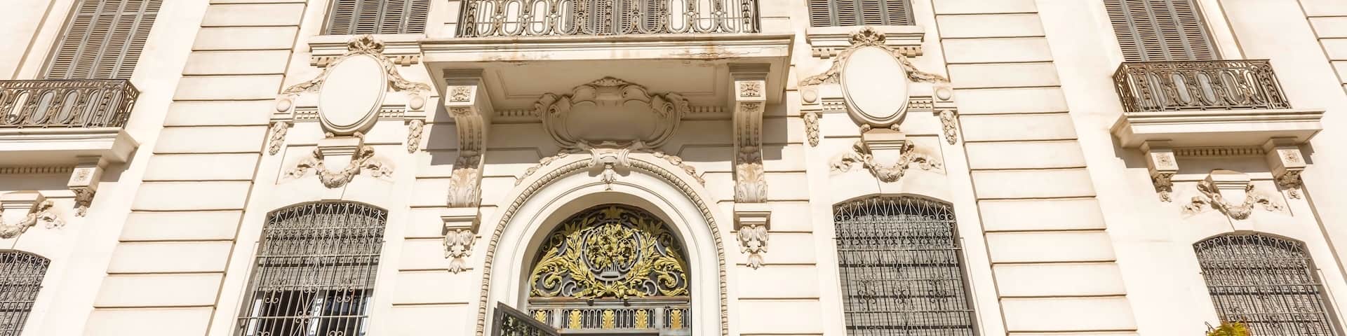 A historic building with ornate architecture, including a large arched entrance and decorative balconies.