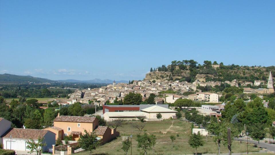 A town with a prominent church on a hill, surrounded by residential buildings and greenery.