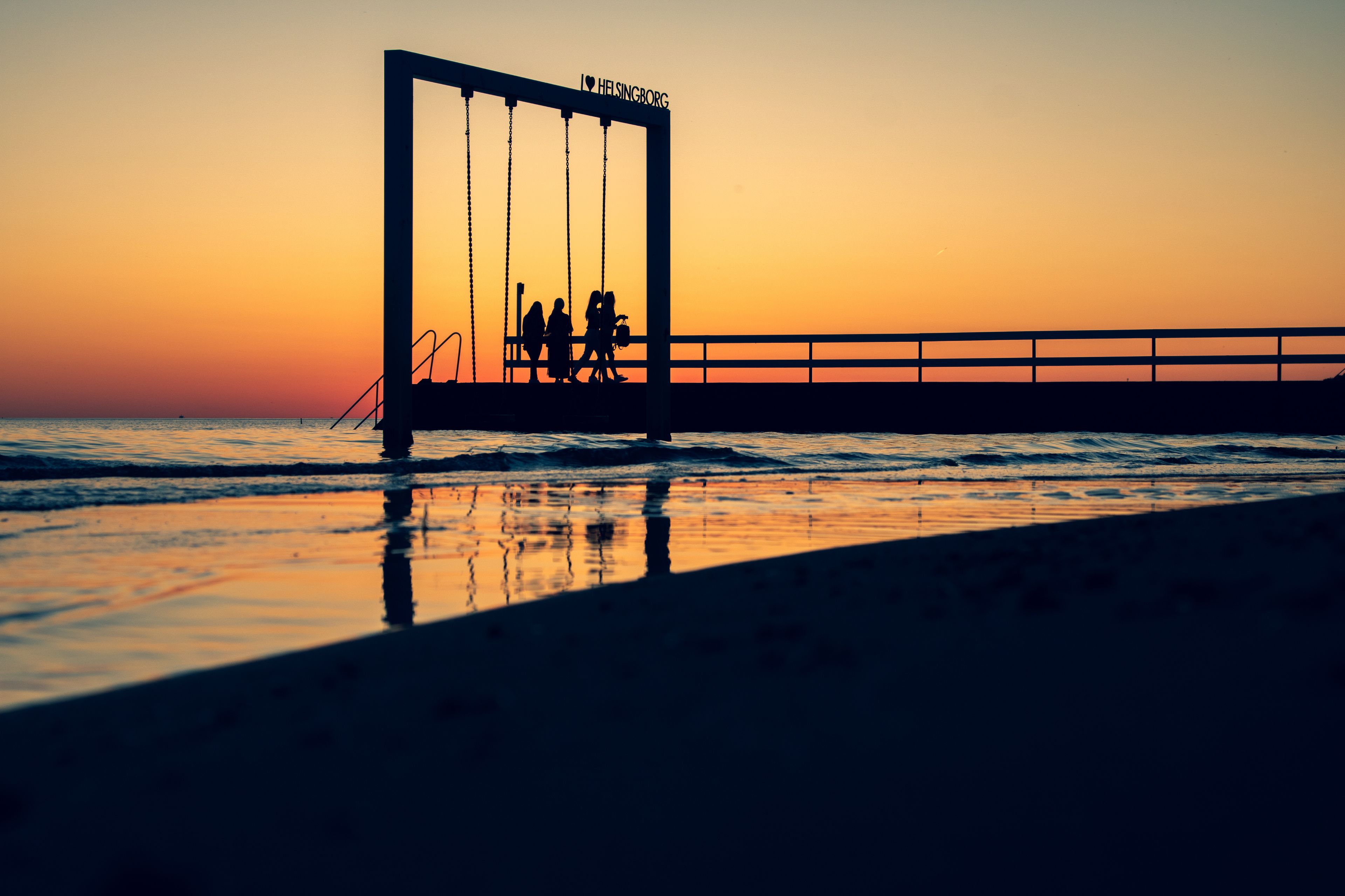 SWING IN THE SEA and sunset on the beach of Helsingborg Sweden 
