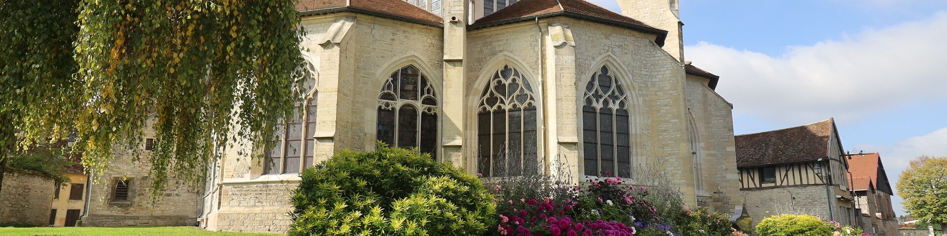 Una iglesia histórica con amplias ventanas de arco y fachada de piedra.