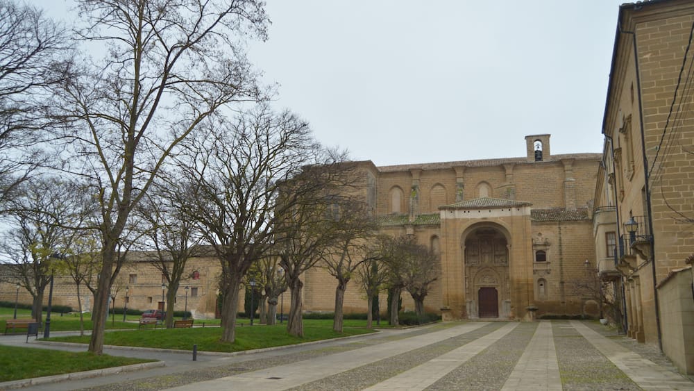 Une cour intérieure agrémentée d’un bâtiment historique, d’arbres et d’un chemin pavé.