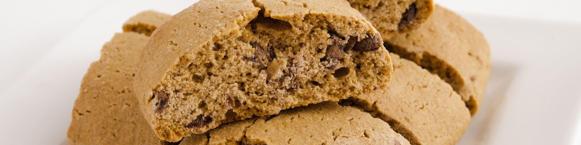 A stack of chocolate chip cookies on a white plate.