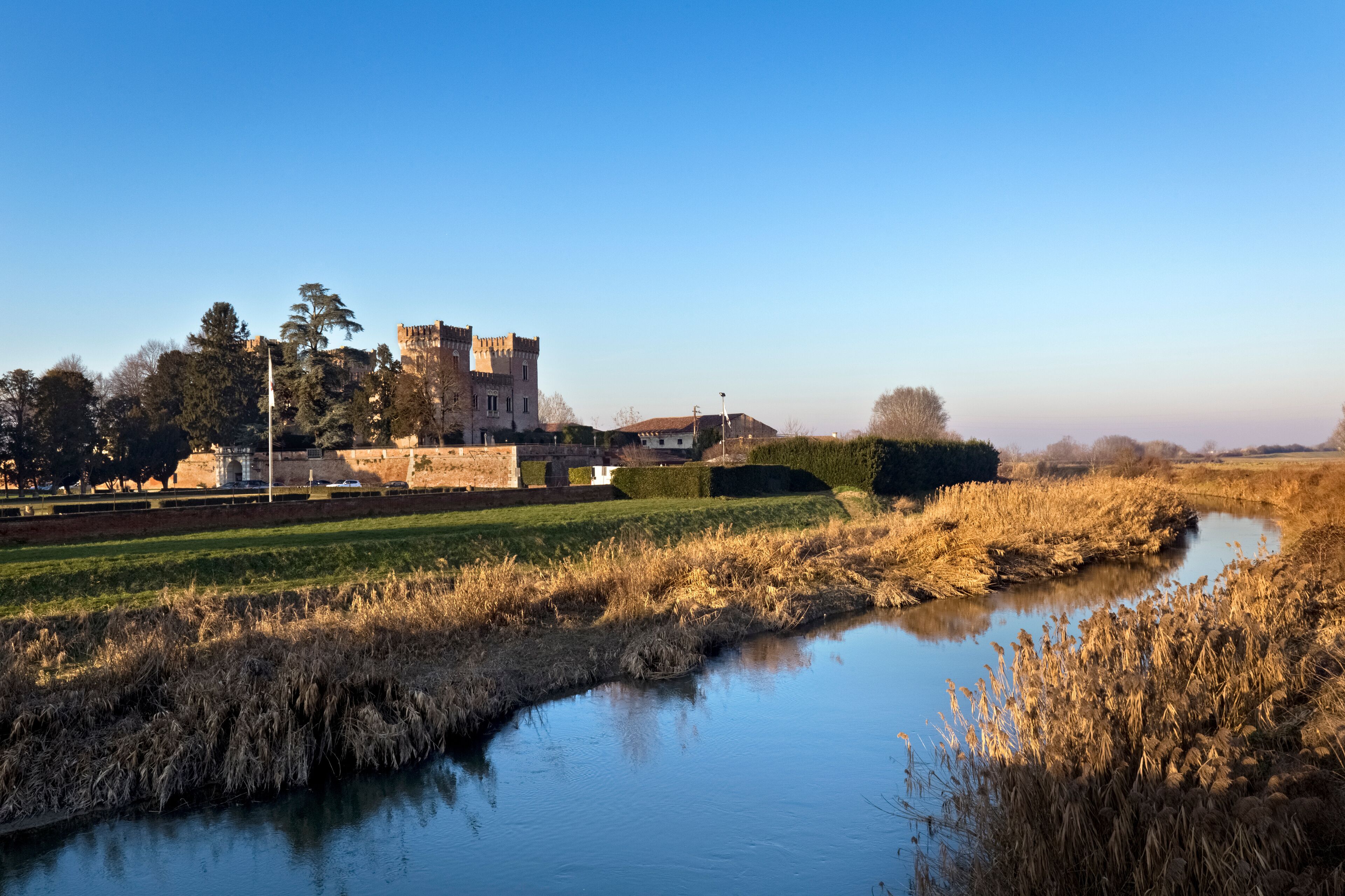 A castle, a river, and a field.