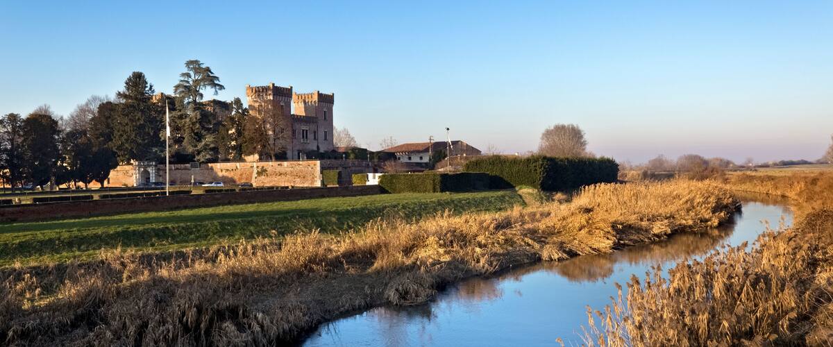 A castle, a river, and a field.