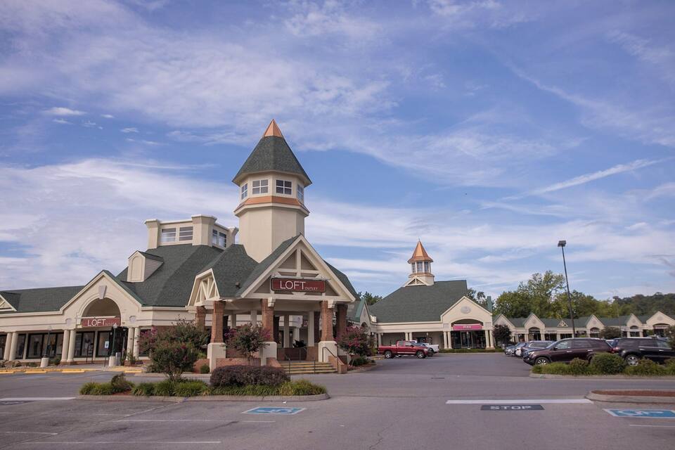 A shopping center with a prominent tower and a sign reading "LOFT OUTLET".