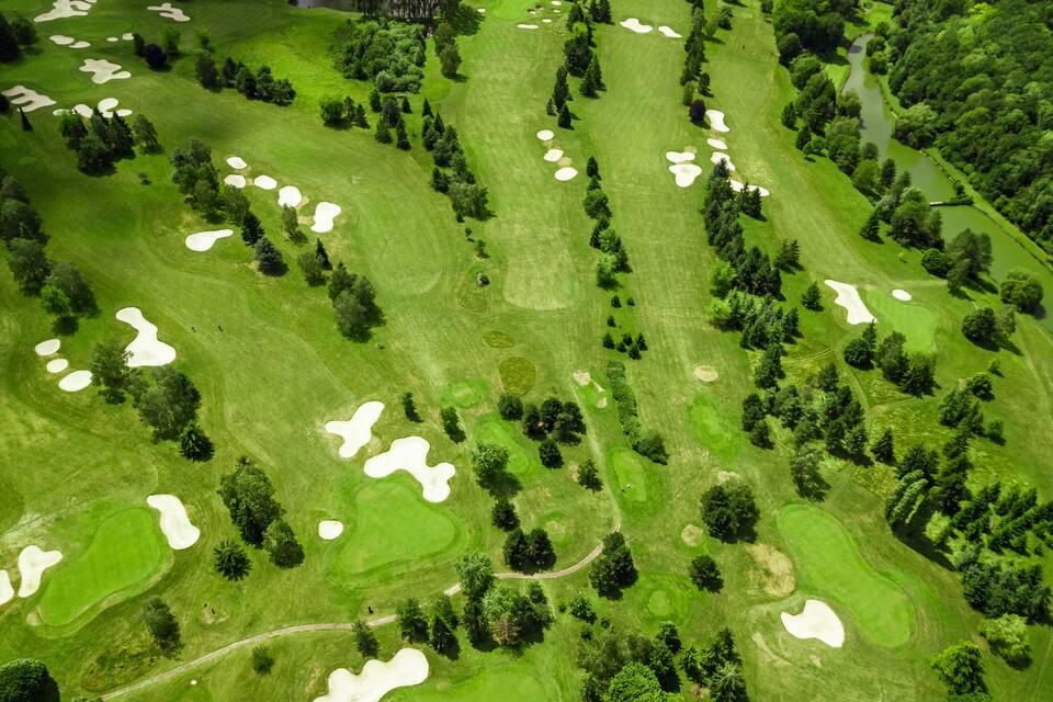 Vista aèria d'un camp de golf amb búnquers de sorra i arbres.