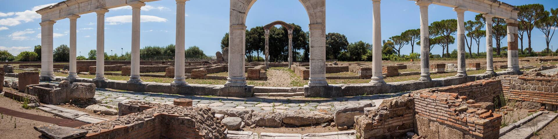 Ancient ruins with a large archway supported by columns.