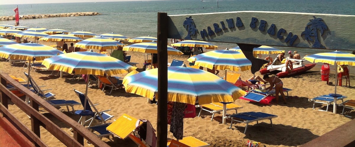 A beach with numerous umbrellas and sun loungers.