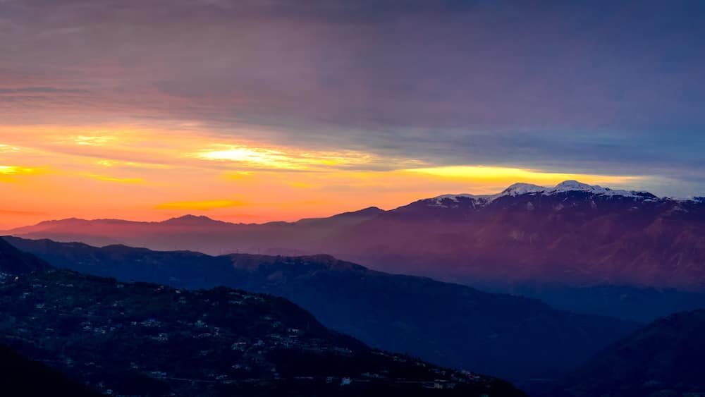 Une chaîne de montagnes au coucher du soleil.