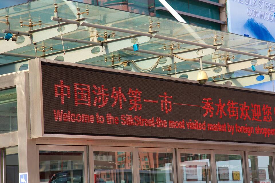 A digital sign with Chinese characters and English text welcoming visitors to the Silk Street market.