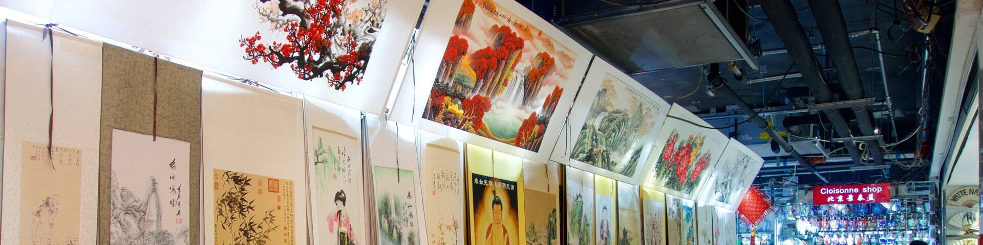 Una exhibición de pinturas tradicionales en un centro comercial.