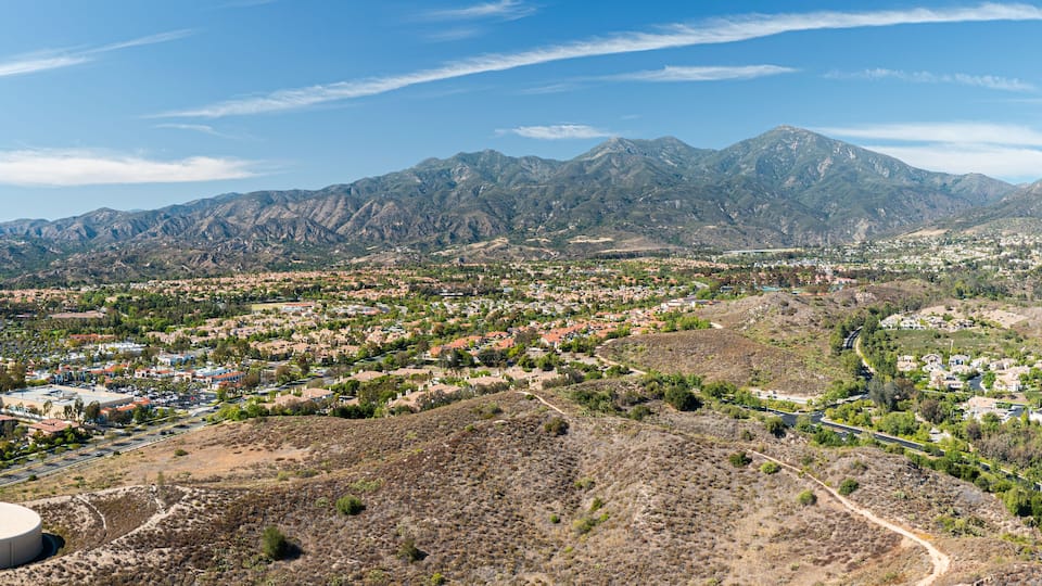 A town nestled in a valley with mountains in the background.