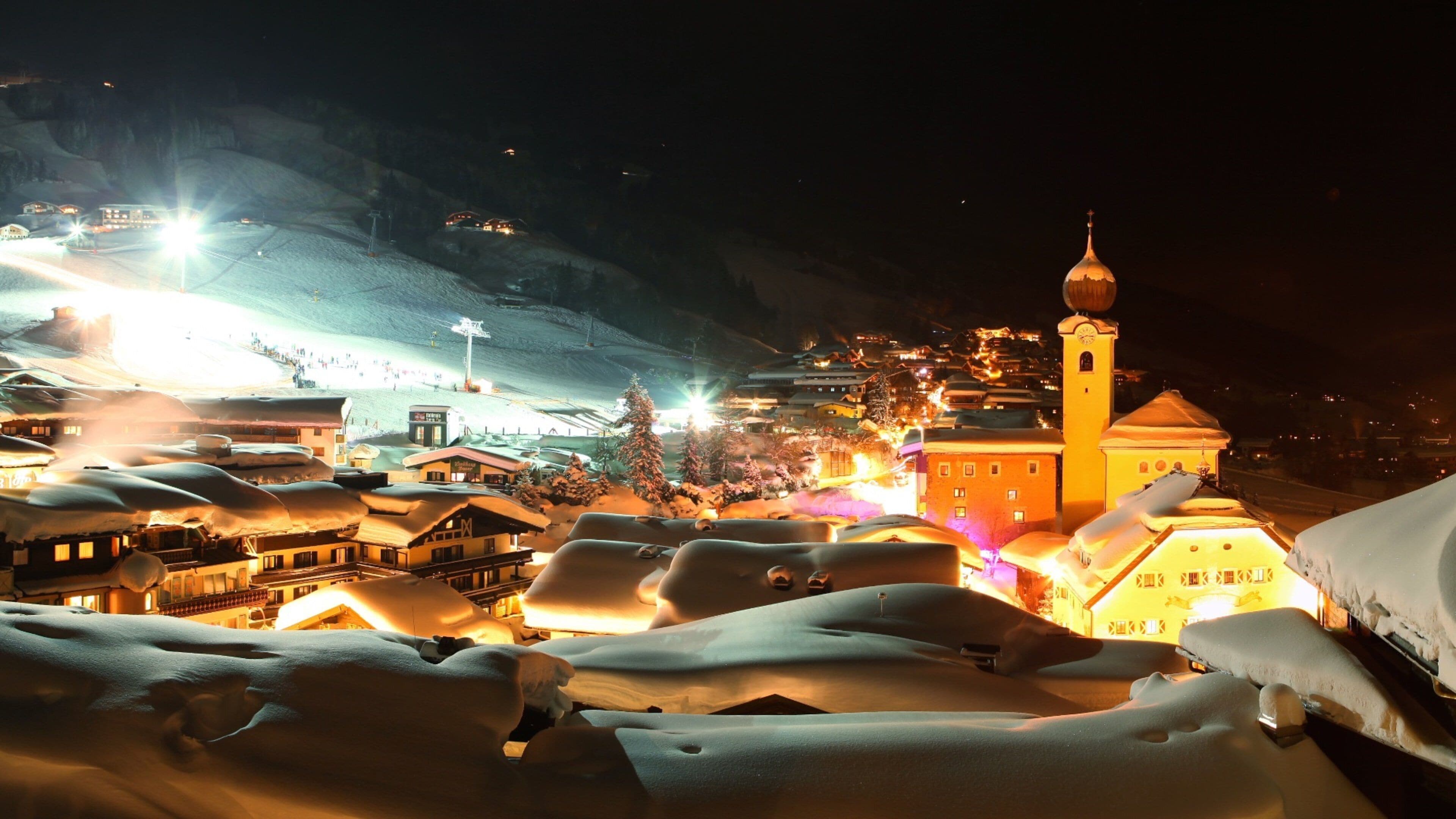 Saalbach-Hinterglemm Ski Resort showing a small town or village, snow and night scenes