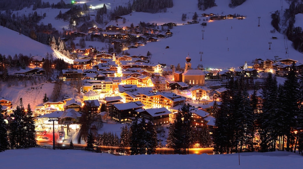 Wintersportort Saalbach-Hinterglemm mit einem Schnee, Kleinstadt oder Dorf und bei Nacht