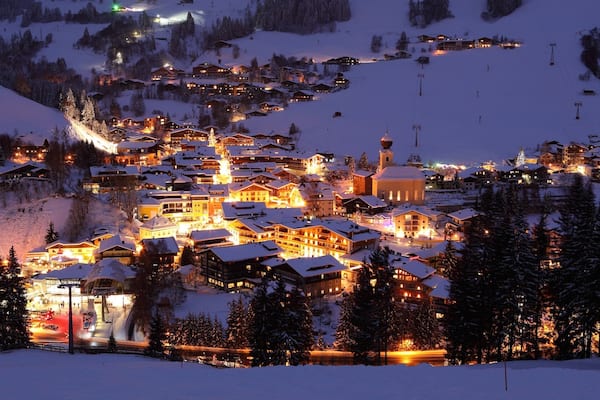 Wintersportort Saalbach-Hinterglemm mit einem Schnee, Kleinstadt oder Dorf und bei Nacht