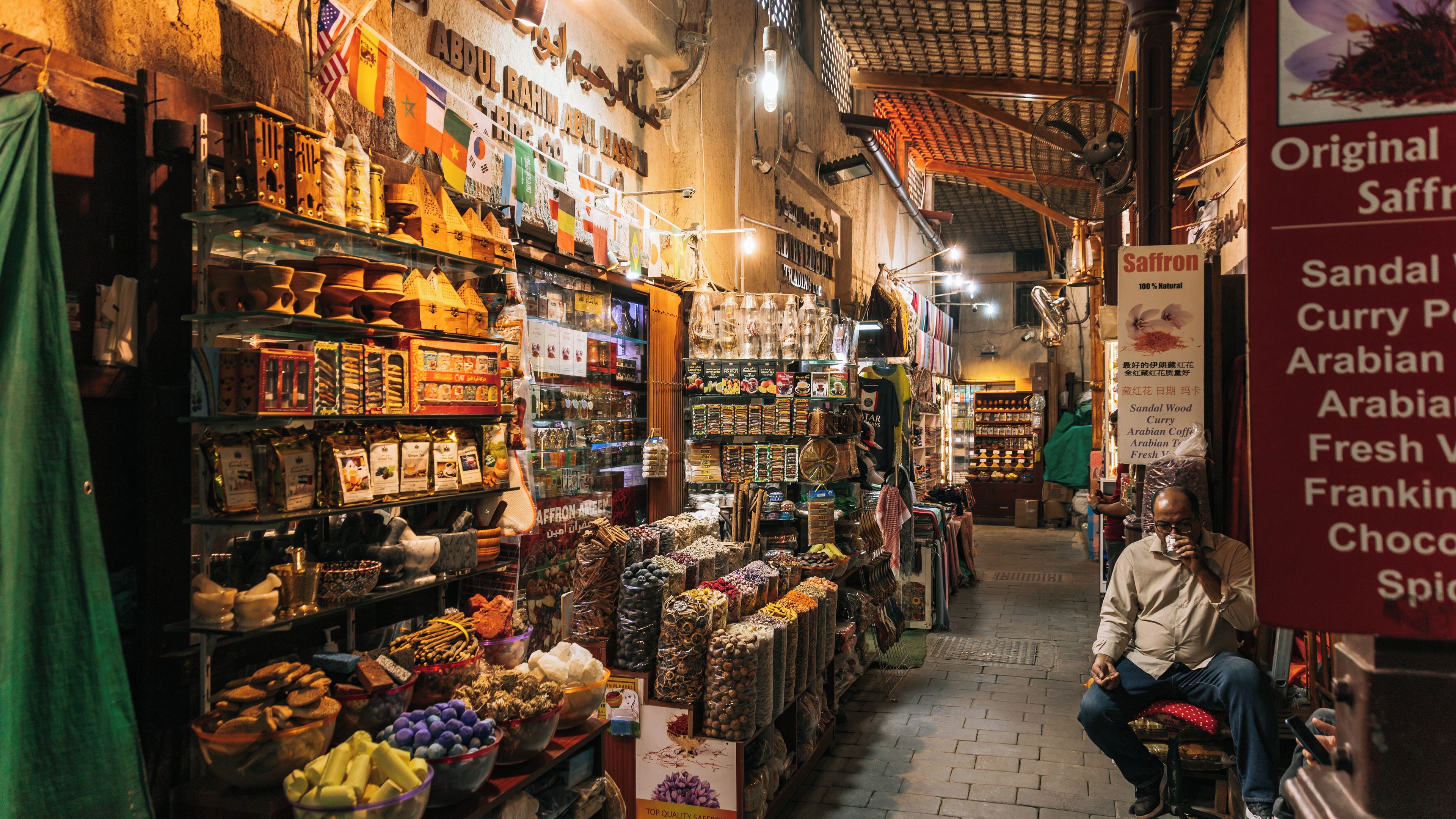 A narrow market street with various shops selling spices, dried fruits, and other goods.