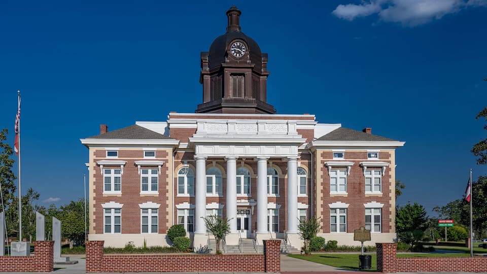 A large brick building with a clock tower and columns.