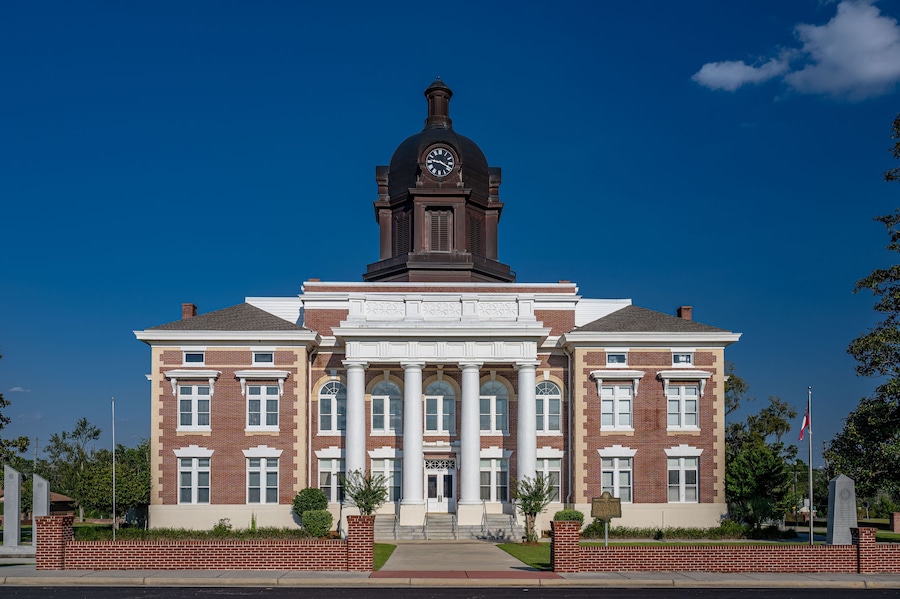 A large brick building with a clock tower and columns.