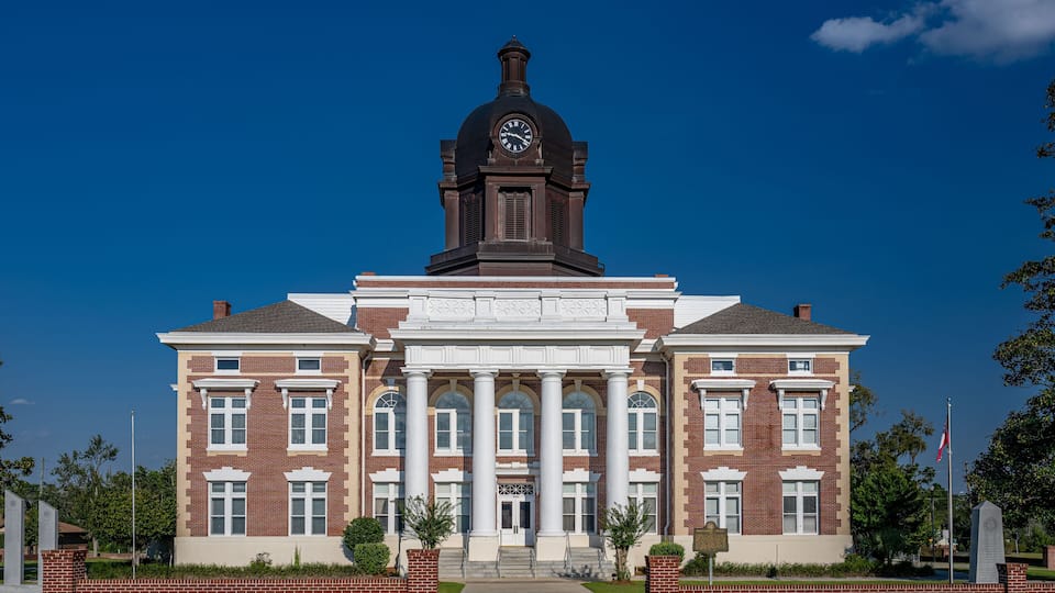 A large brick building with a clock tower and columns.