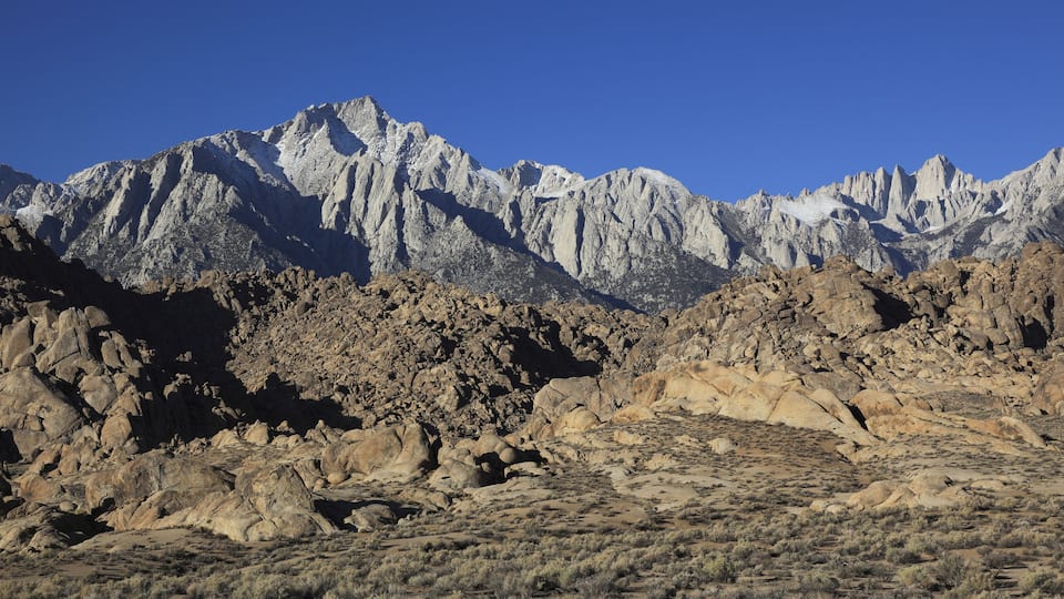 A rugged mountain range with rocky terrain and sparse vegetation.