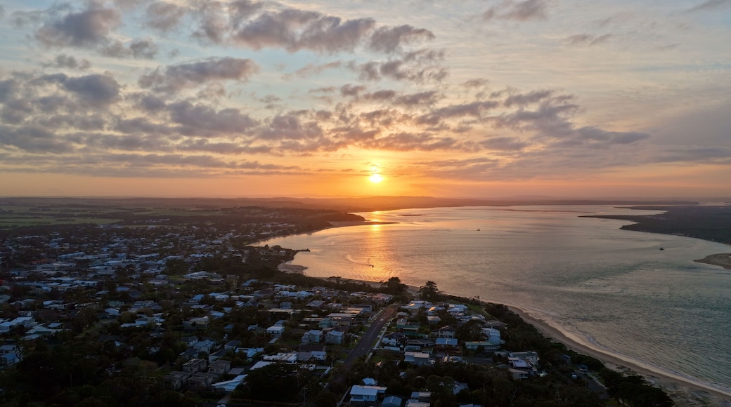 A coastal town at sunset with a river and a beach.