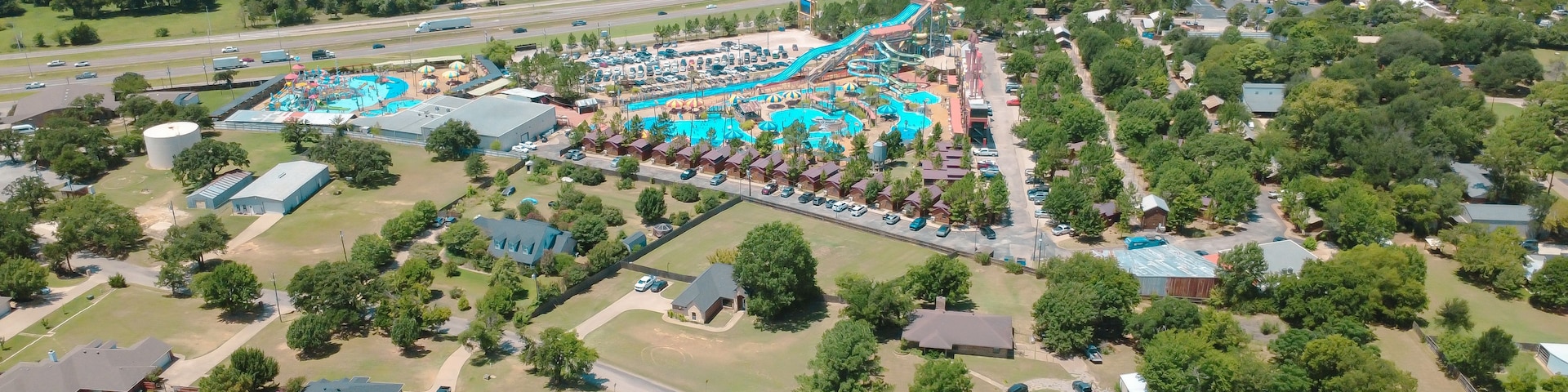 Eine Vogelperspektive eines Themenparks mit Wasserrutsche, Parkplätzen und angrenzenden Wohngebieten.
