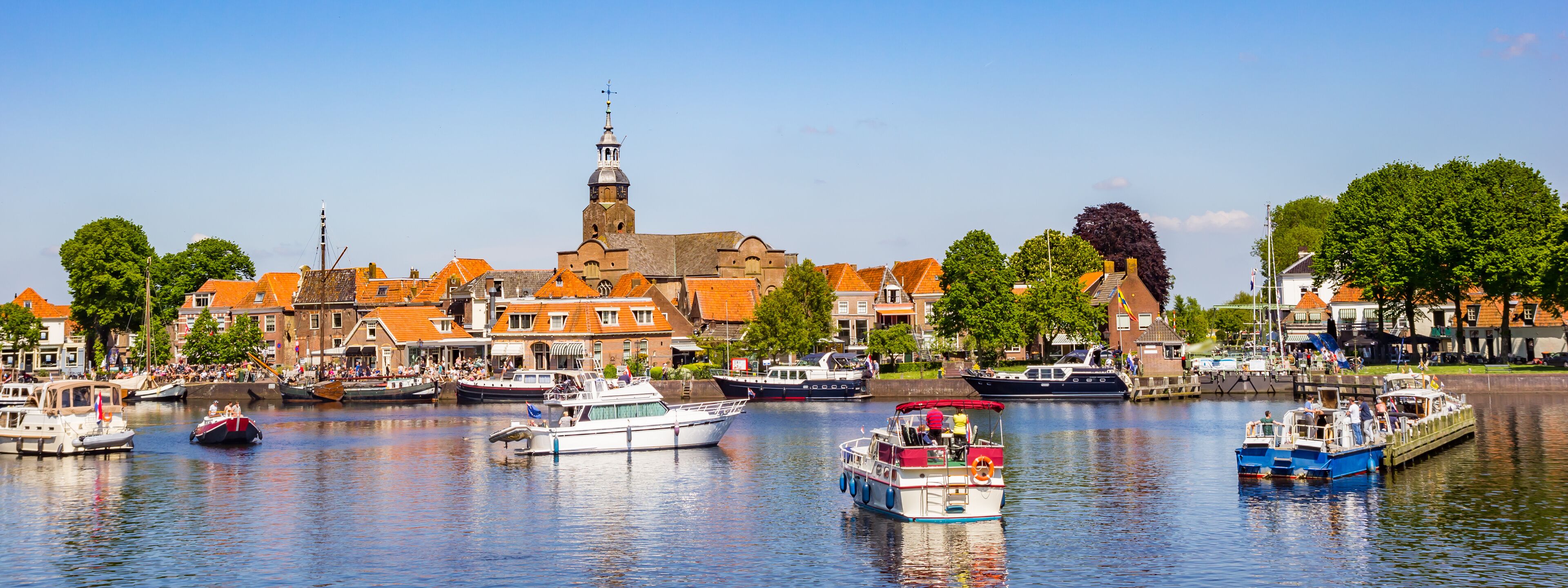 A canal with boats, a church, and buildings along the water.