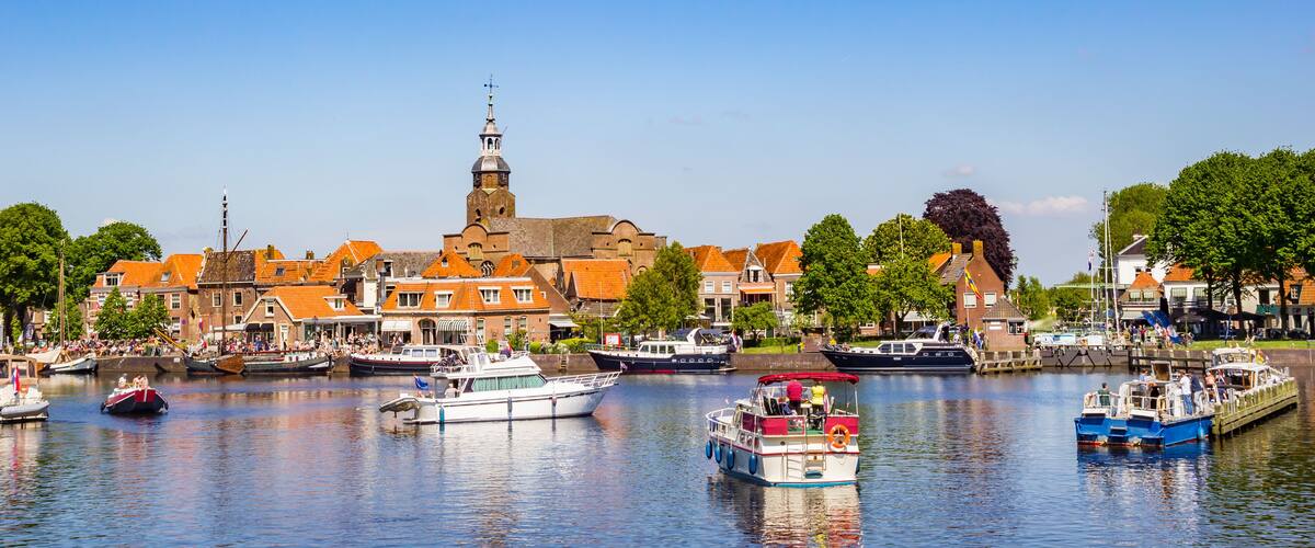 A canal with boats, a church, and buildings along the water.